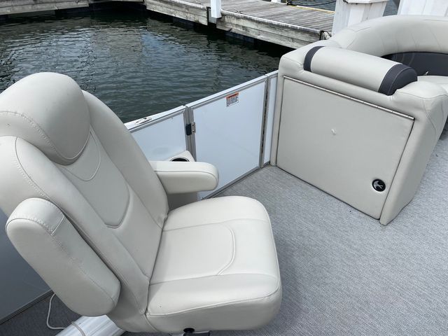 A white seat on a boat with a dock in the background