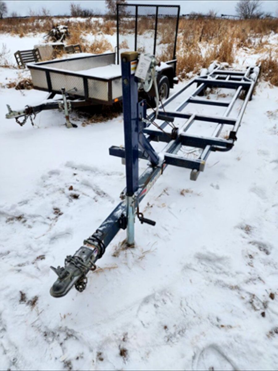 A trailer is sitting in the snow next to another trailer