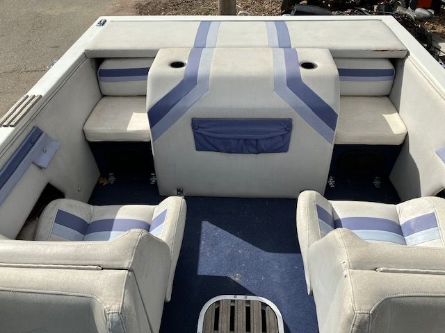 The inside of a boat with blue and white stripes on the seats