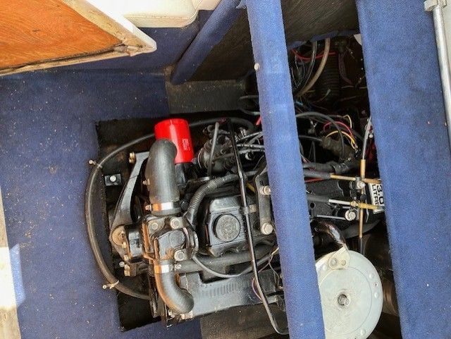 A boat engine is sitting under a blue carpet