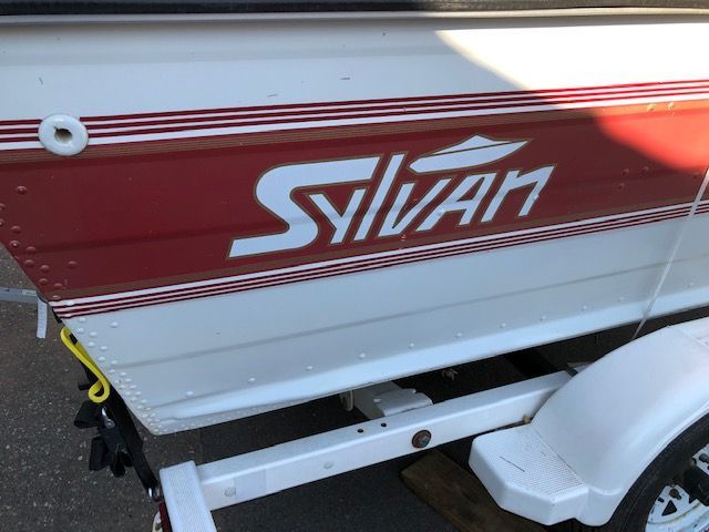 Red and white Sylvan boat on a trailer
