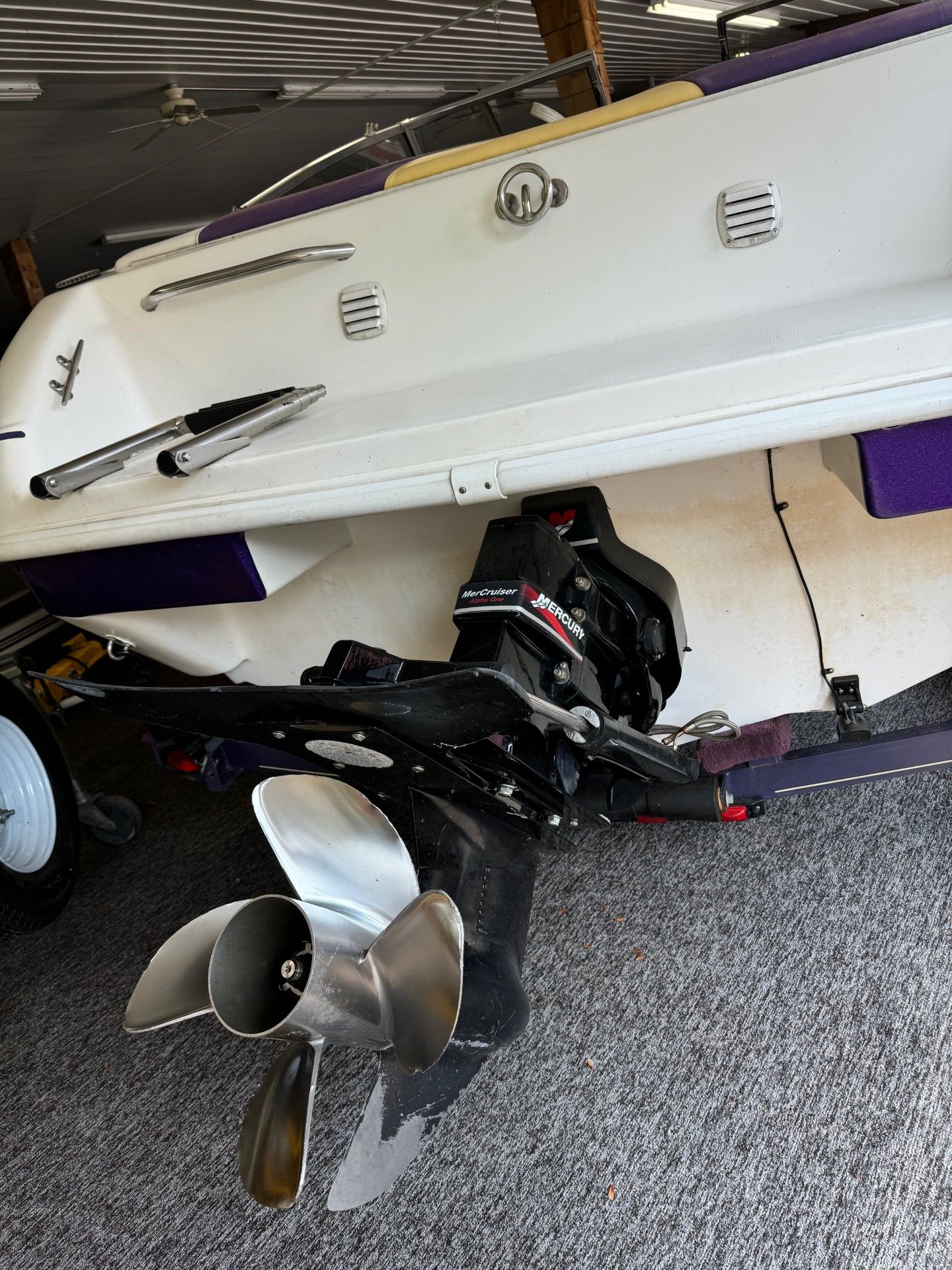 A white and purple boat with a stainless steel propeller