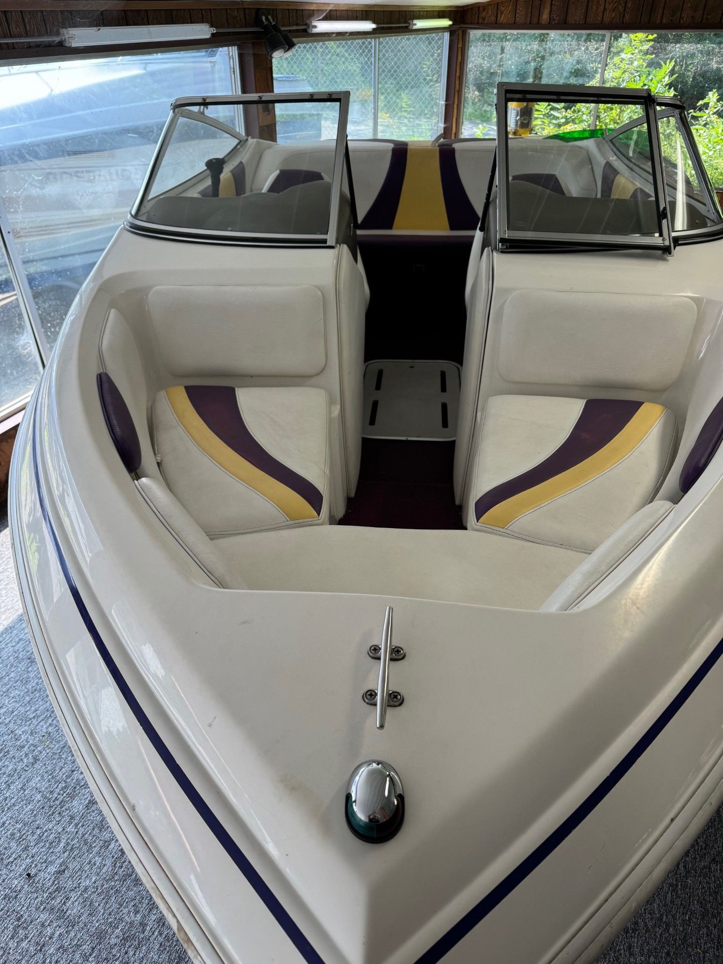 A white boat with purple and yellow seats