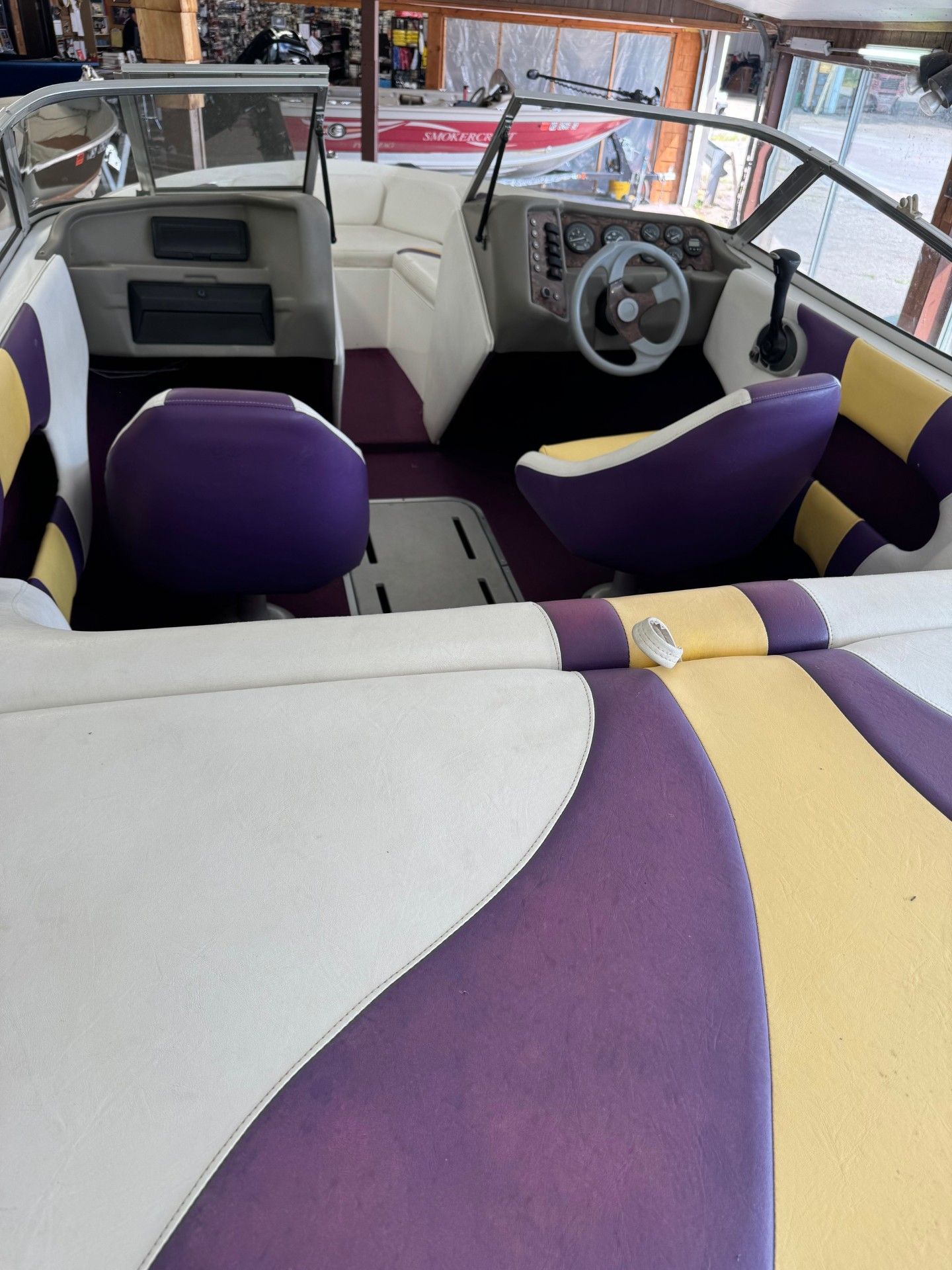 A boat with purple and yellow seats and a steering wheel