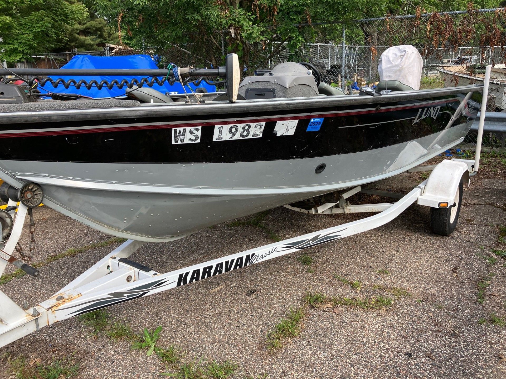 Aluminum fishing boat on a trailer, black and gray with 