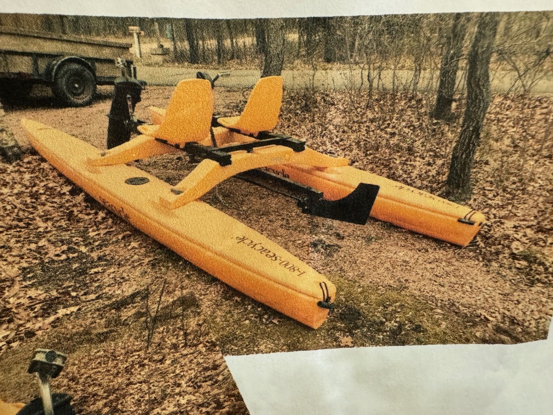 A yellow sea cycle water bike is sitting on top of a pile of leaves