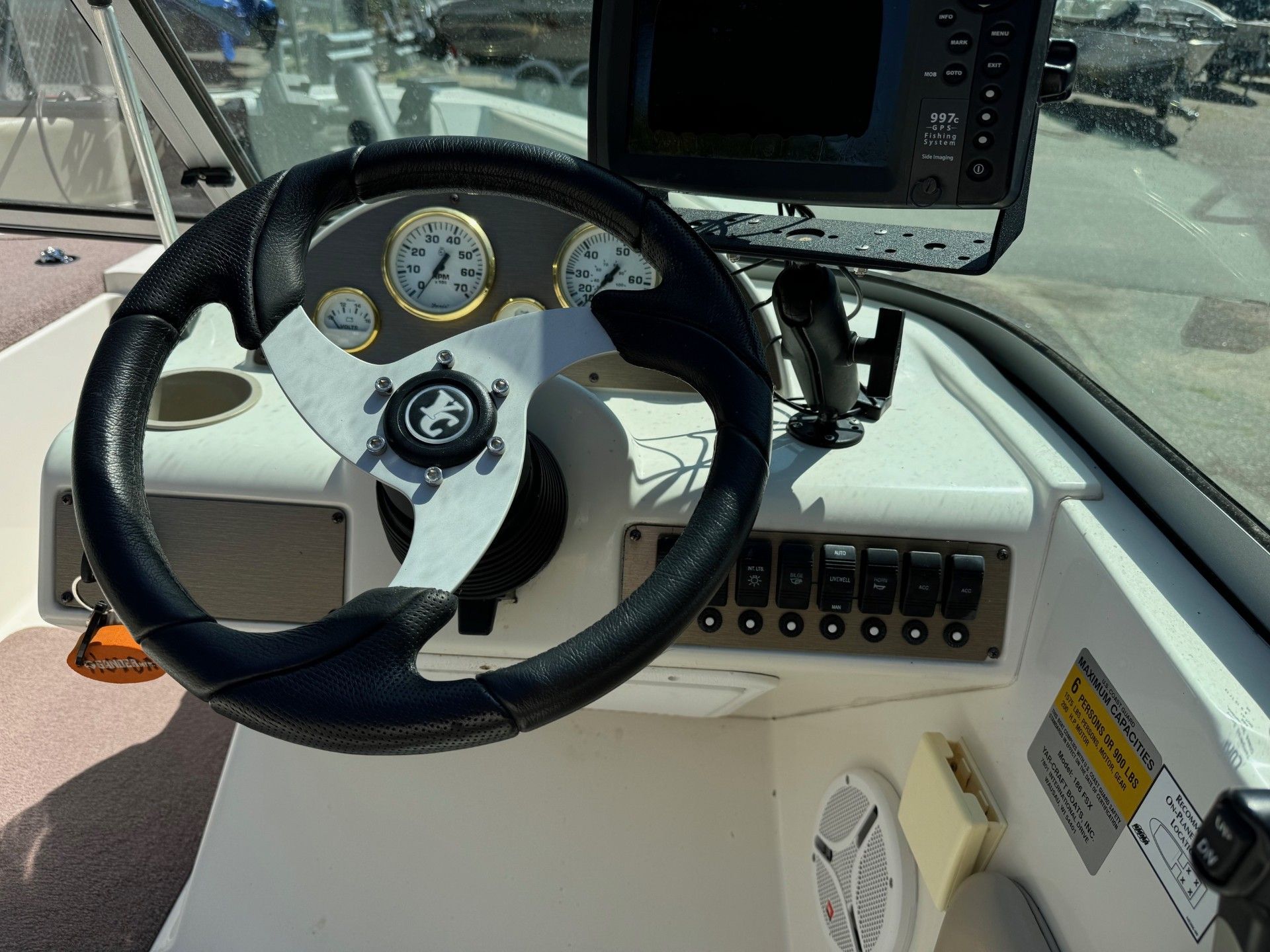 A boat with a steering wheel and a GPS on it.