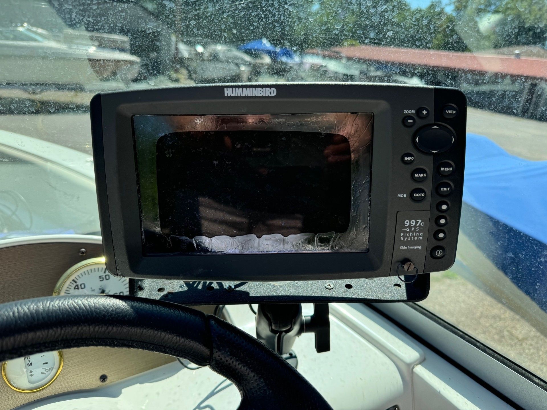 A gps device is mounted on the dashboard of a boat.