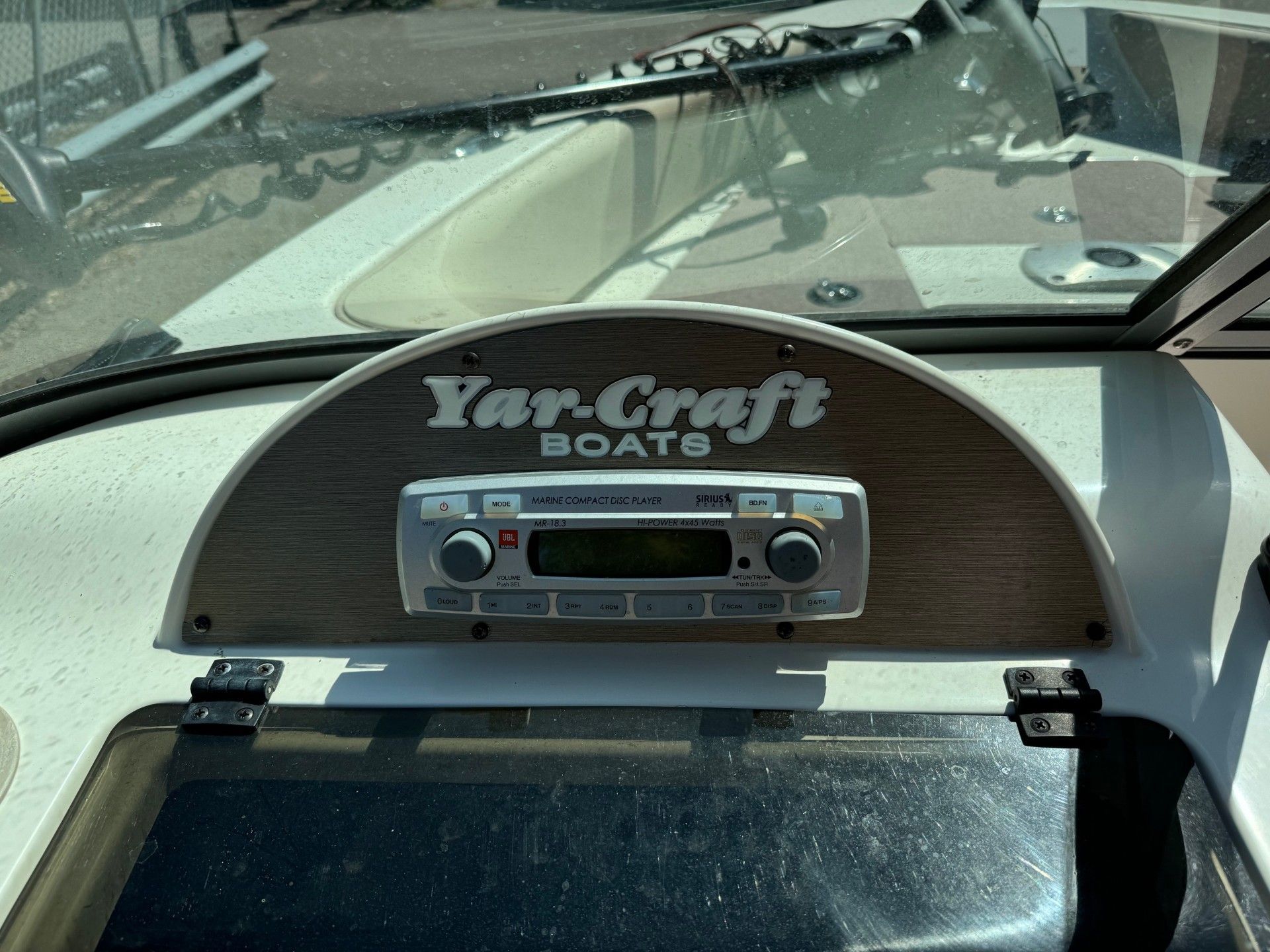 A yar craft boat has a radio on the dashboard.