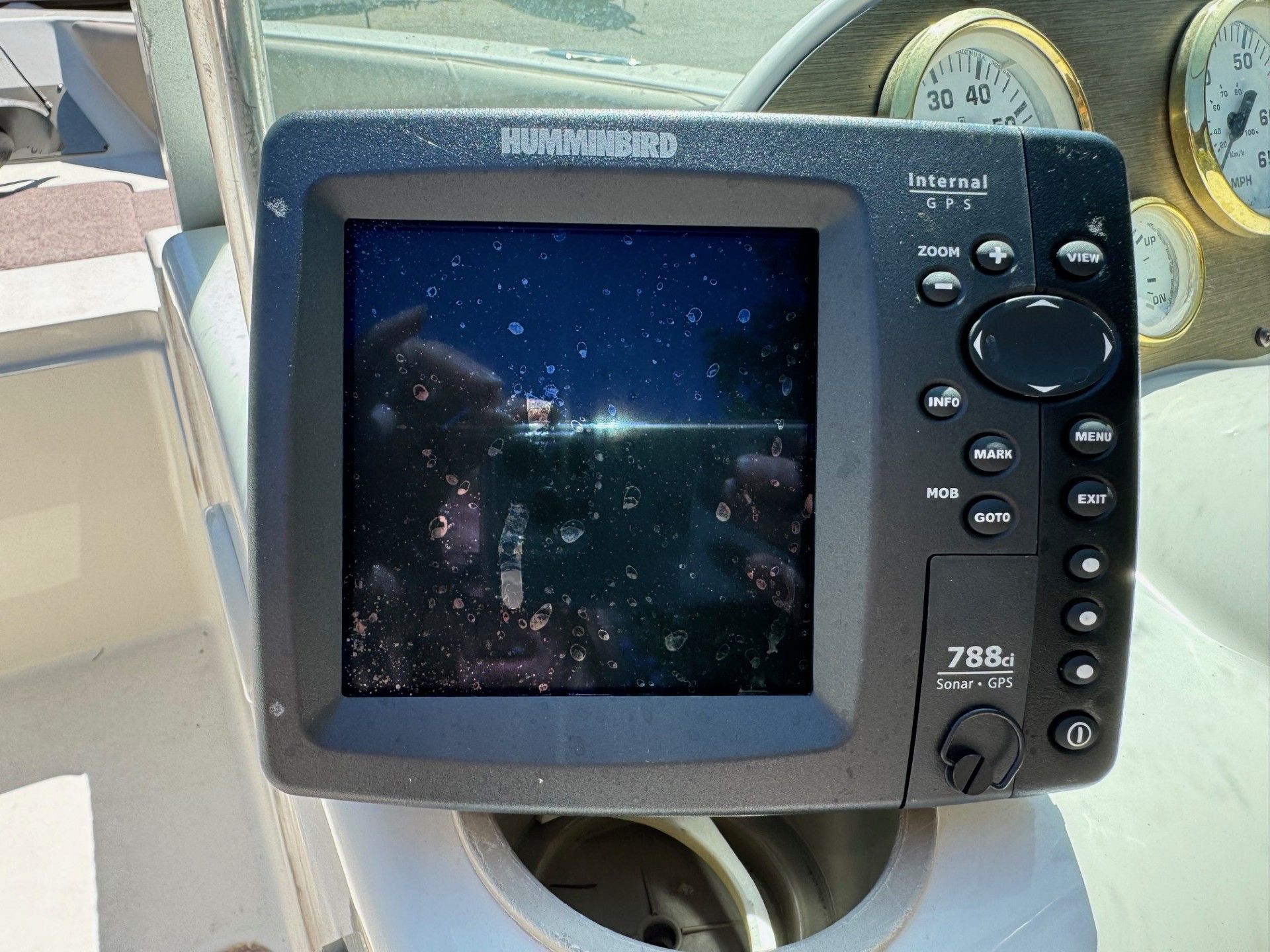 A humminbird device is sitting on a boat.