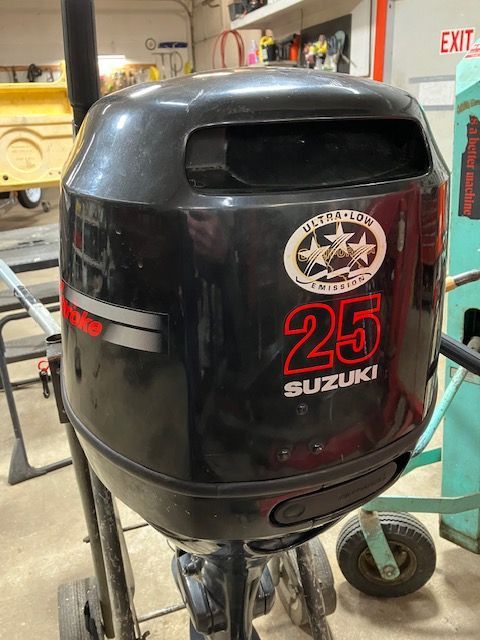 A suzuki outboard motor with the number 25 on it