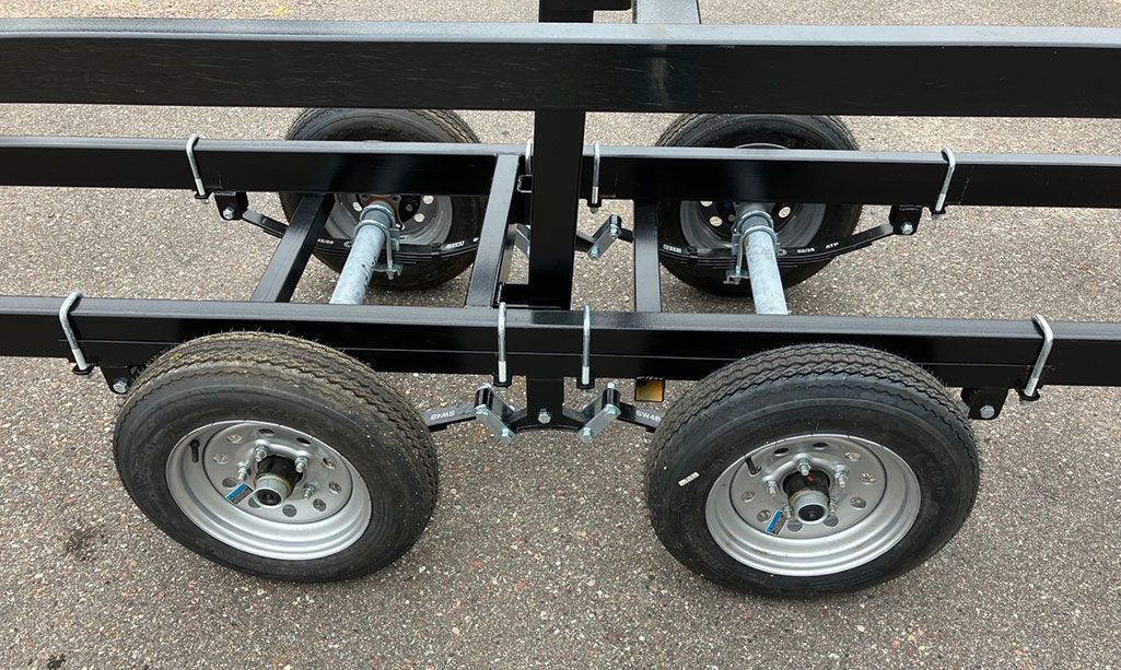 Black trailer frame with four tires.