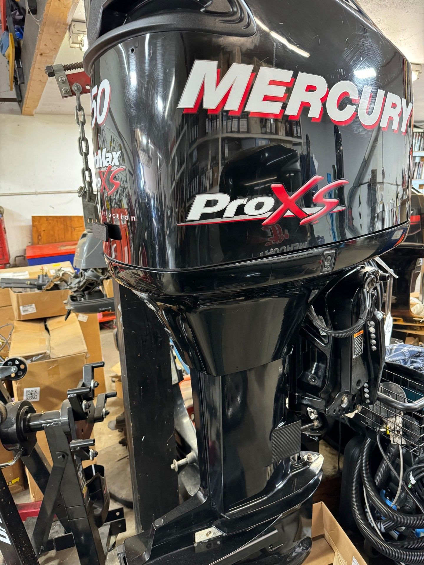 A mercury outboard motor is sitting in a garage.