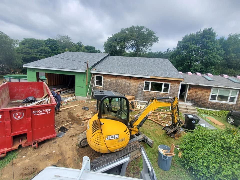 Backyard renovation with yellow excavator, red dumpster, and house exterior under repair