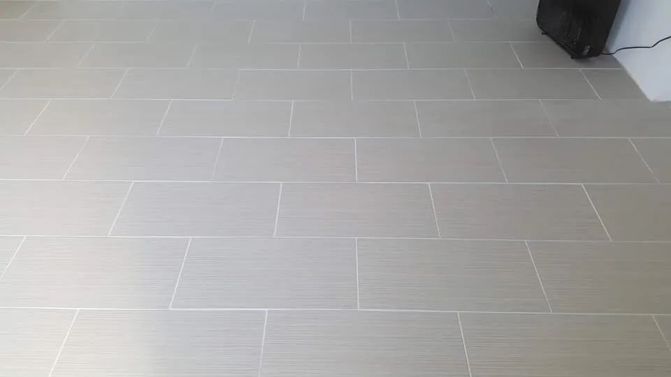 Light gray tiled floor with a dark object partially visible at the upper right edge.
