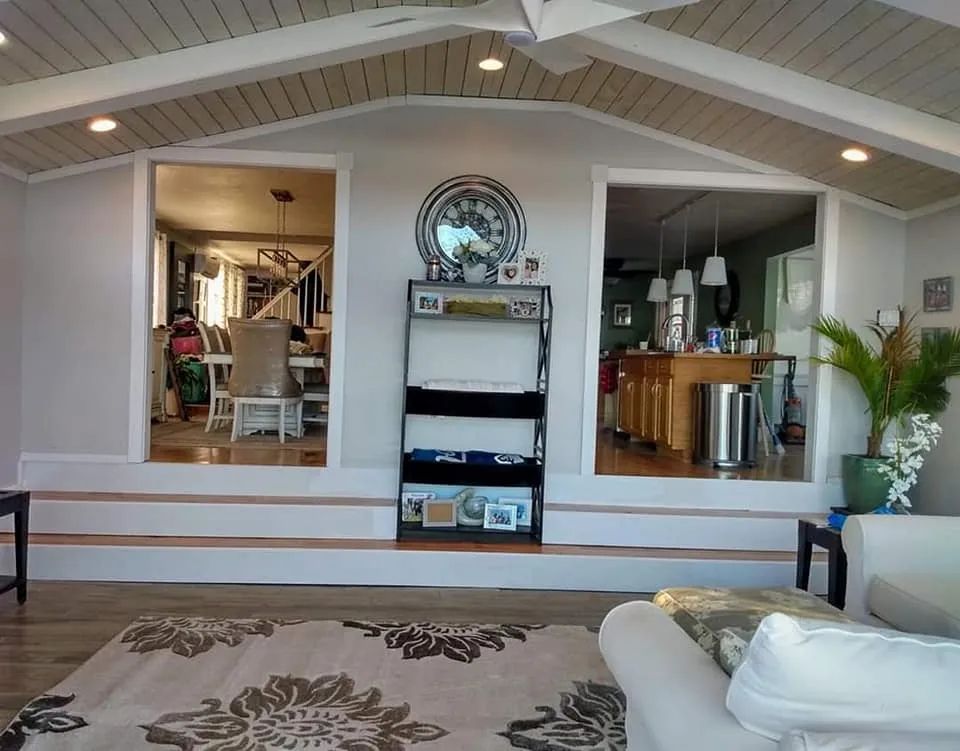 Bright living room with vaulted ceiling, open kitchen, and white sofa in the foreground