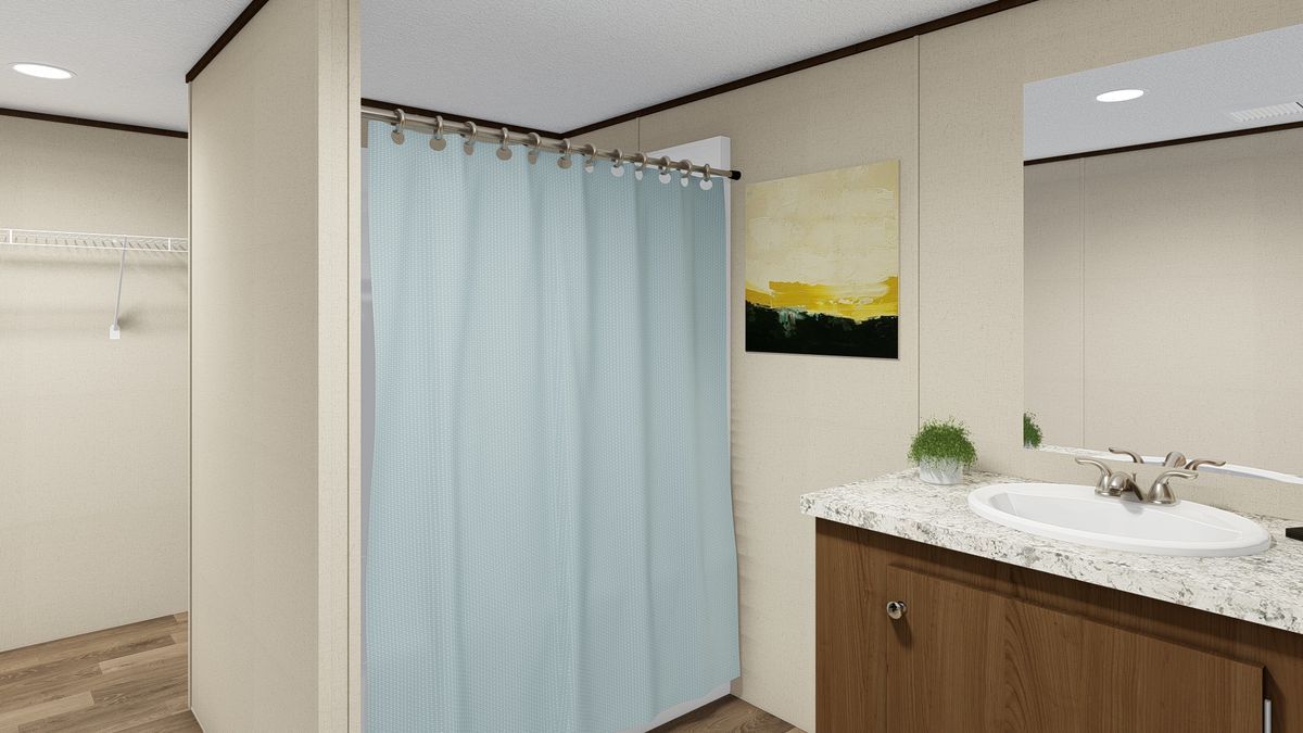 Bathroom interior: shower with blue curtain, vanity with sink, artwork, and mirror.