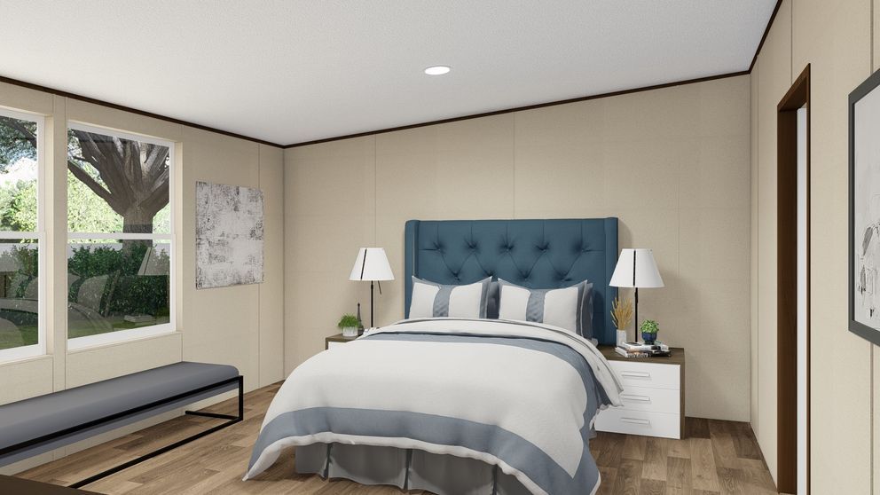 Bedroom with blue upholstered headboard, bed, nightstands, bench, and large window.