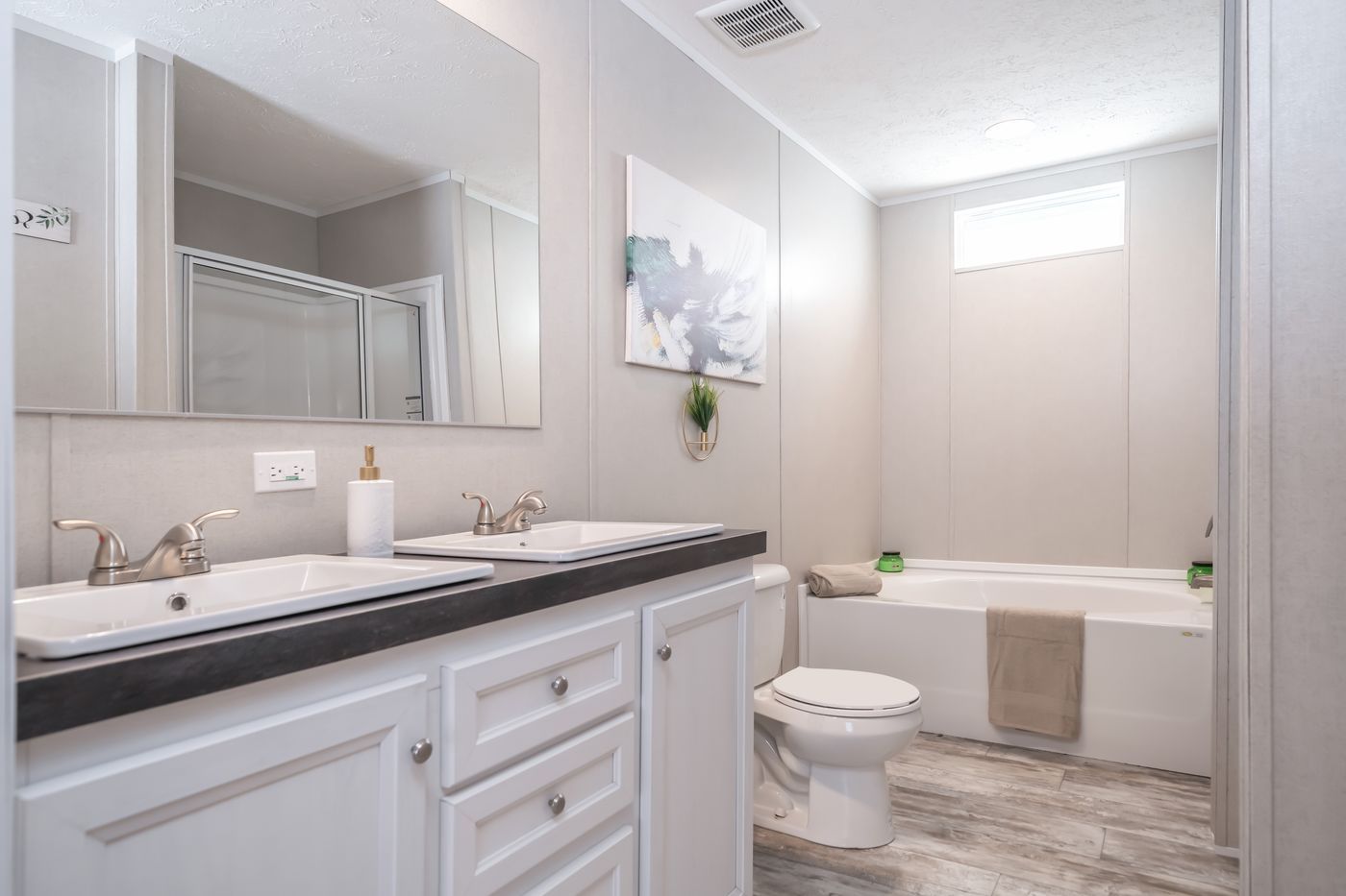 Bathroom with double vanity, soaking tub, and white cabinetry.