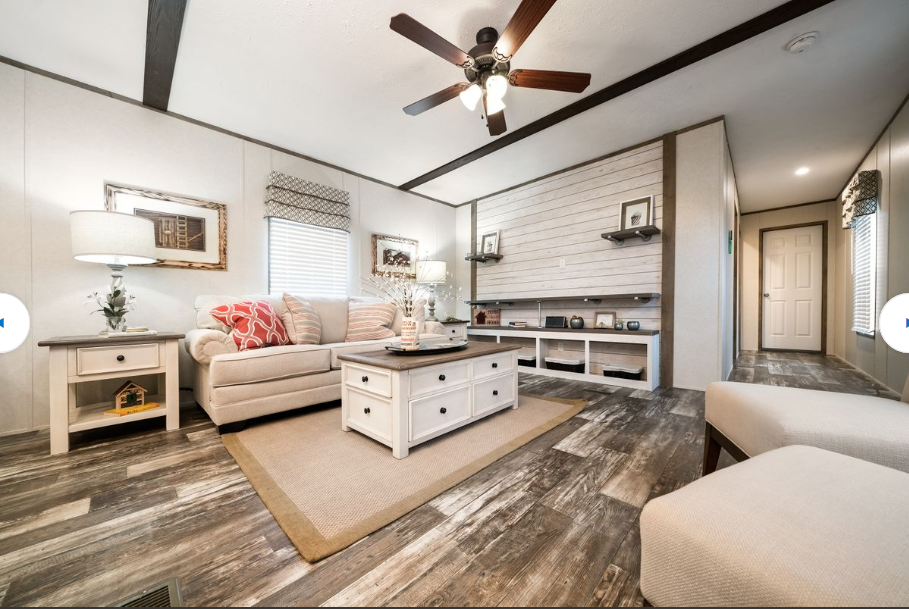 Living room with white walls, gray wood-look flooring, beige sofa, coffee table, and white side table.