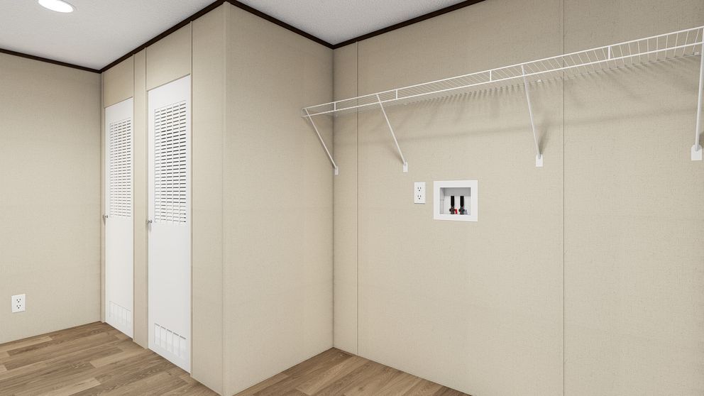 A laundry room with a washing machine, wire shelving, and electrical outlet.