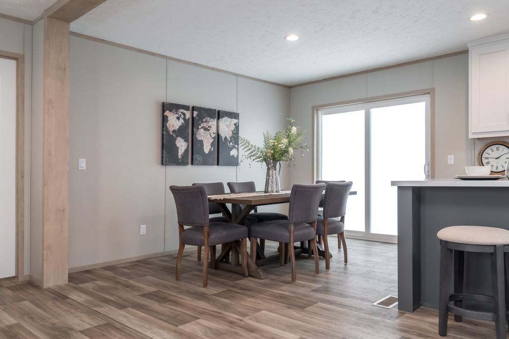 Dining area with gray walls, a wooden table, and six gray chairs. Sliding door, world map art.