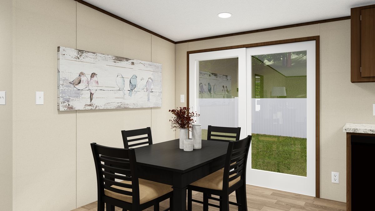 Dining area: black table, chairs, art, and patio door to outside, neutral walls, light wood-look floor.