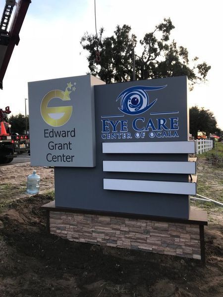 Sign for Edward Grant Center and Eye Care Center of Ocala, with gray and beige design and text.