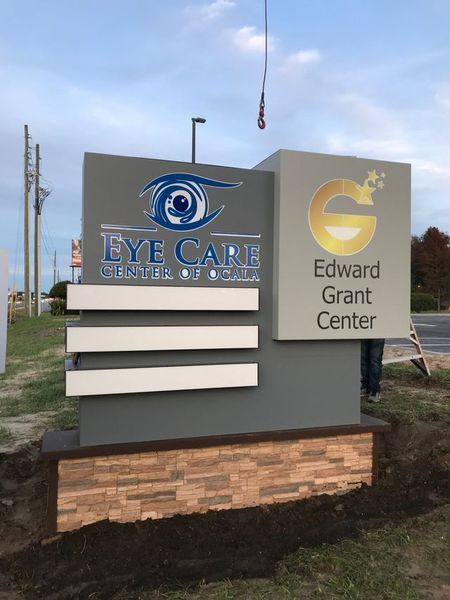 Sign for Eye Care Center of SC and Edward Grant Center, grey and tan with blue eye logo.