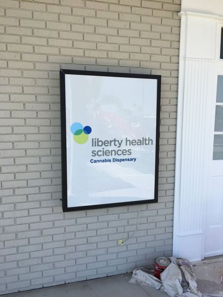 Sign for Liberty Health Sciences Cannabis Dispensary on a brick building.