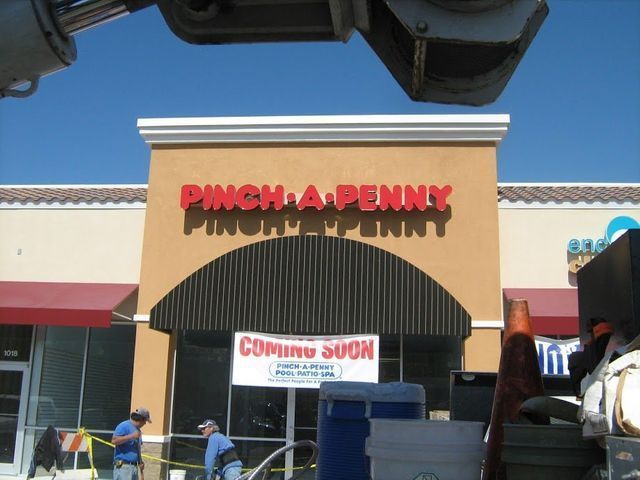 Pinch A Penny store under construction, with red letters, awning, and a 