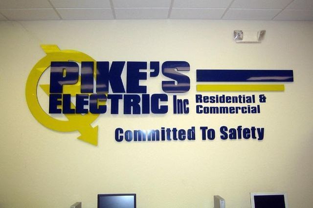 Pike's Electric Inc. logo on a wall, yellow and blue. Text reads 