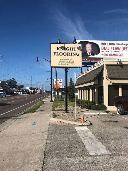 Sign for Knight Flooring, building, sidewalk, street, billboard.