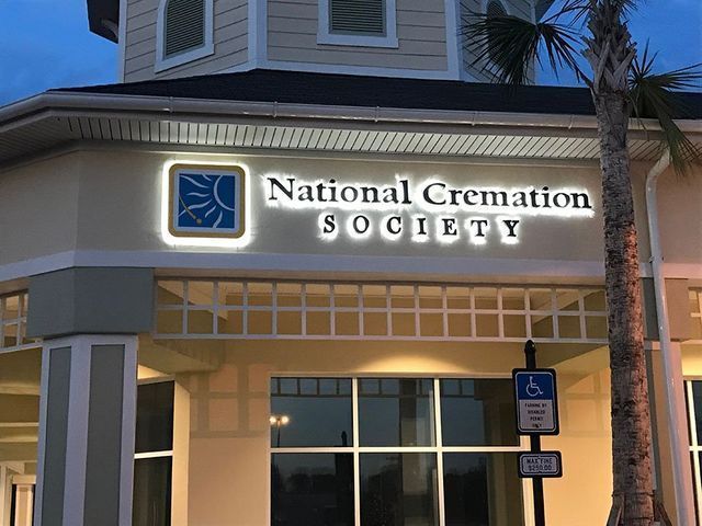 National Cremation Society building exterior with illuminated sign and accessible parking.