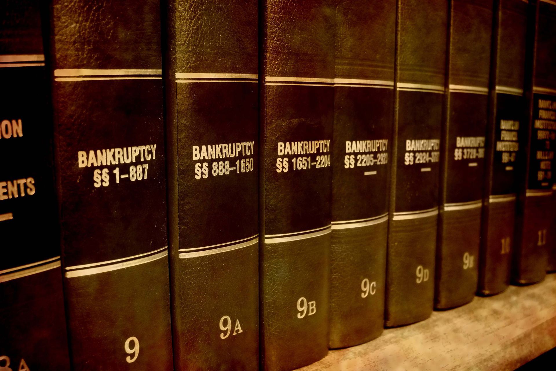 Row of brown law books labeled “Bankruptcy” on a shelf, viewed close up