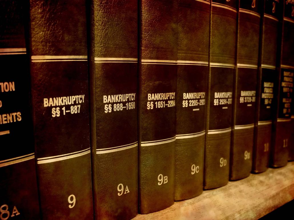 Row of brown legal books on a shelf, labeled bankruptcy cases
