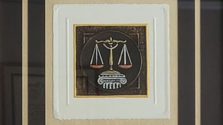 Framed justice symbol with scales above a courthouse building icon on a dark background