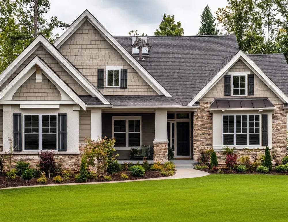 A two-story suburban house with a stone and shingle exterior, gray roof, and a well-manicured green front lawn.