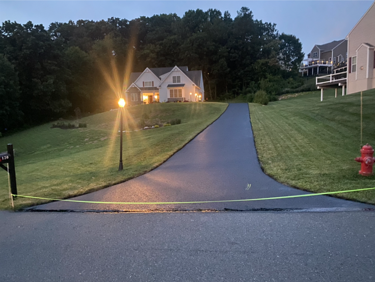 A fire hydrant is on the side of the road in front of a house
