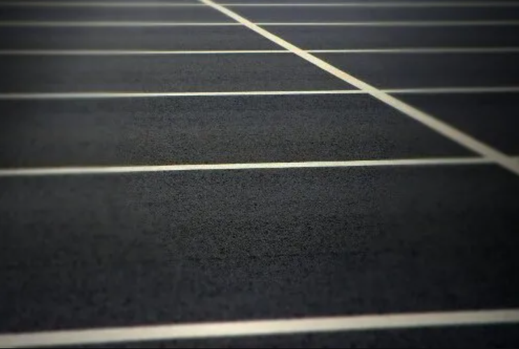 A close up of a parking lot with white lines on it.