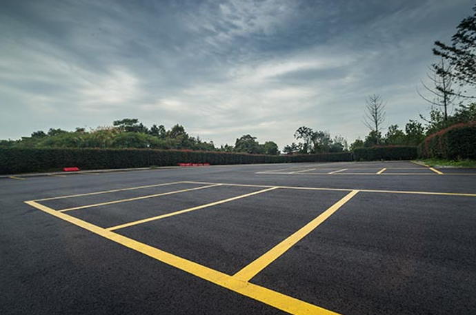 An empty parking lot with yellow lines on the asphalt.