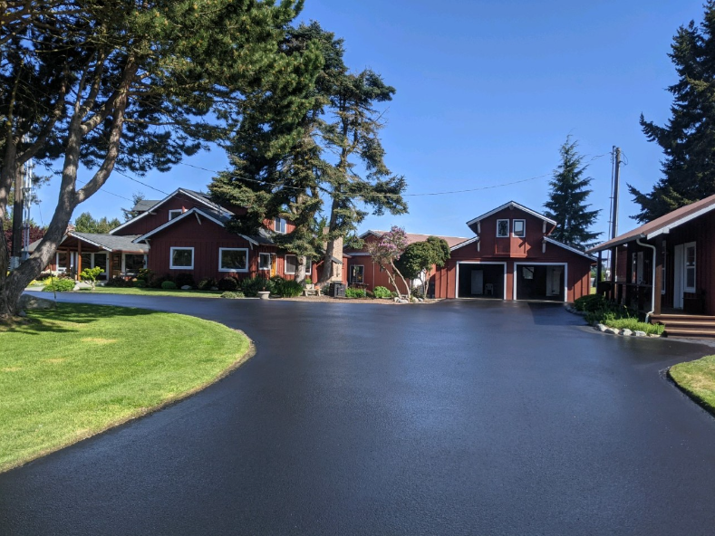 A row of red houses with a black driveway in front of them.