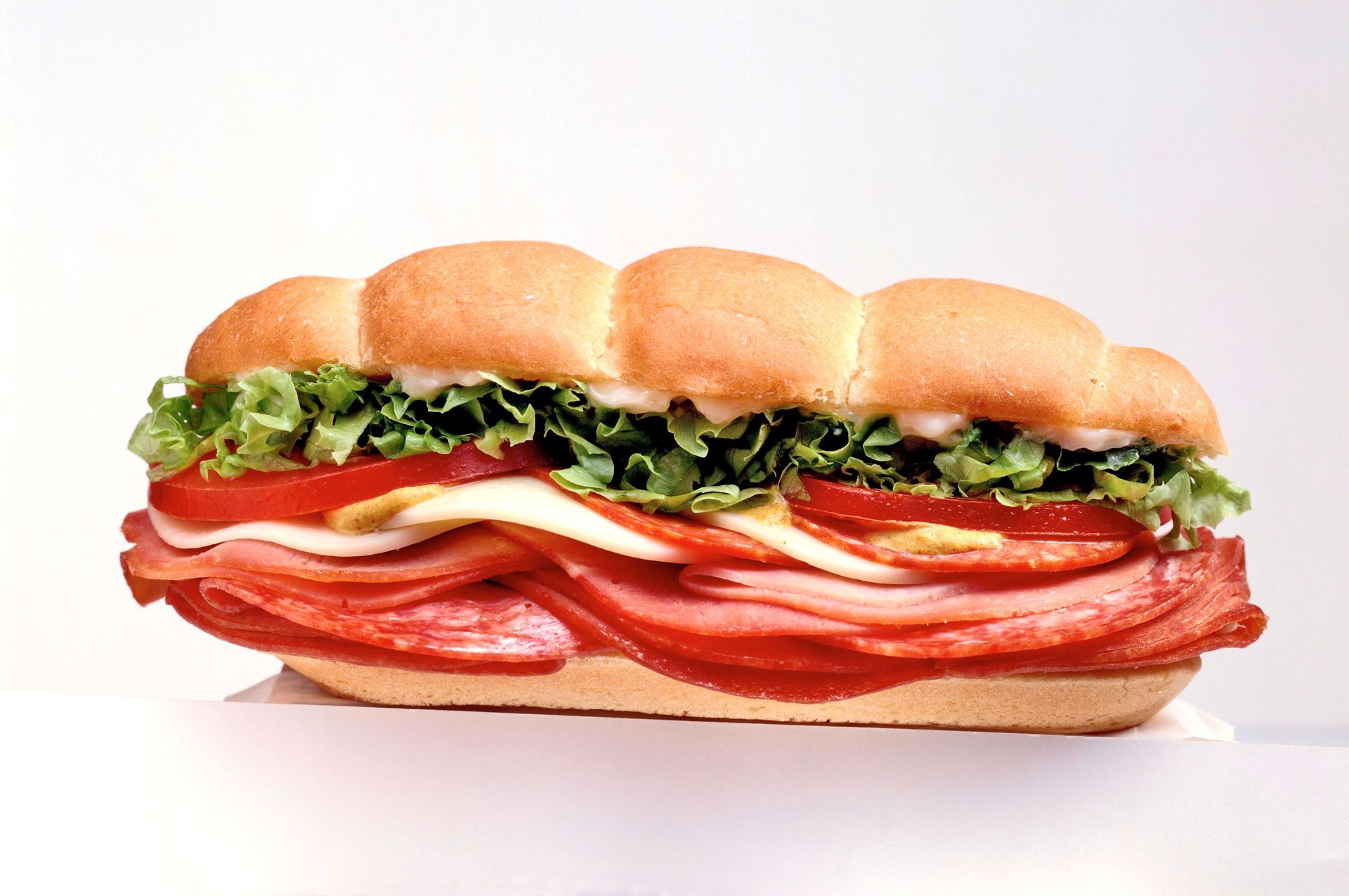 A slice of pizza on a plate next to a can of tomato sauce