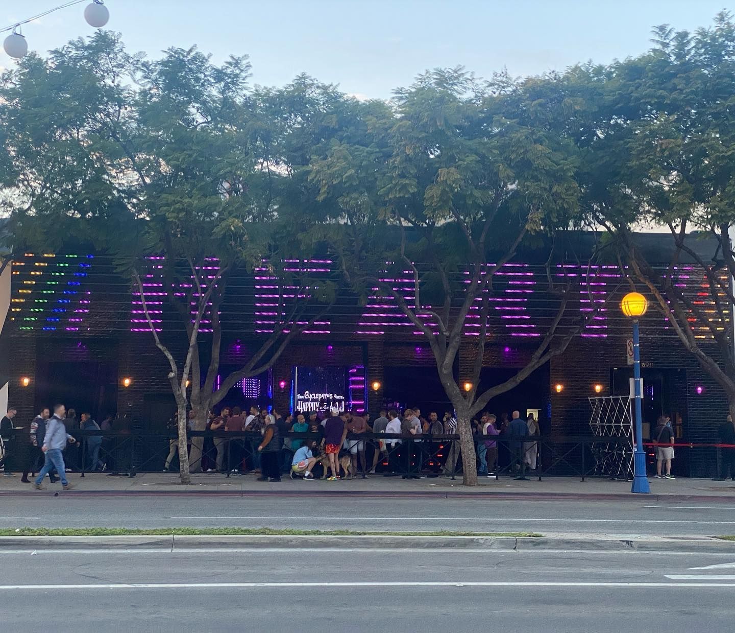 A crowd of people are gathered outside of a building that says beam