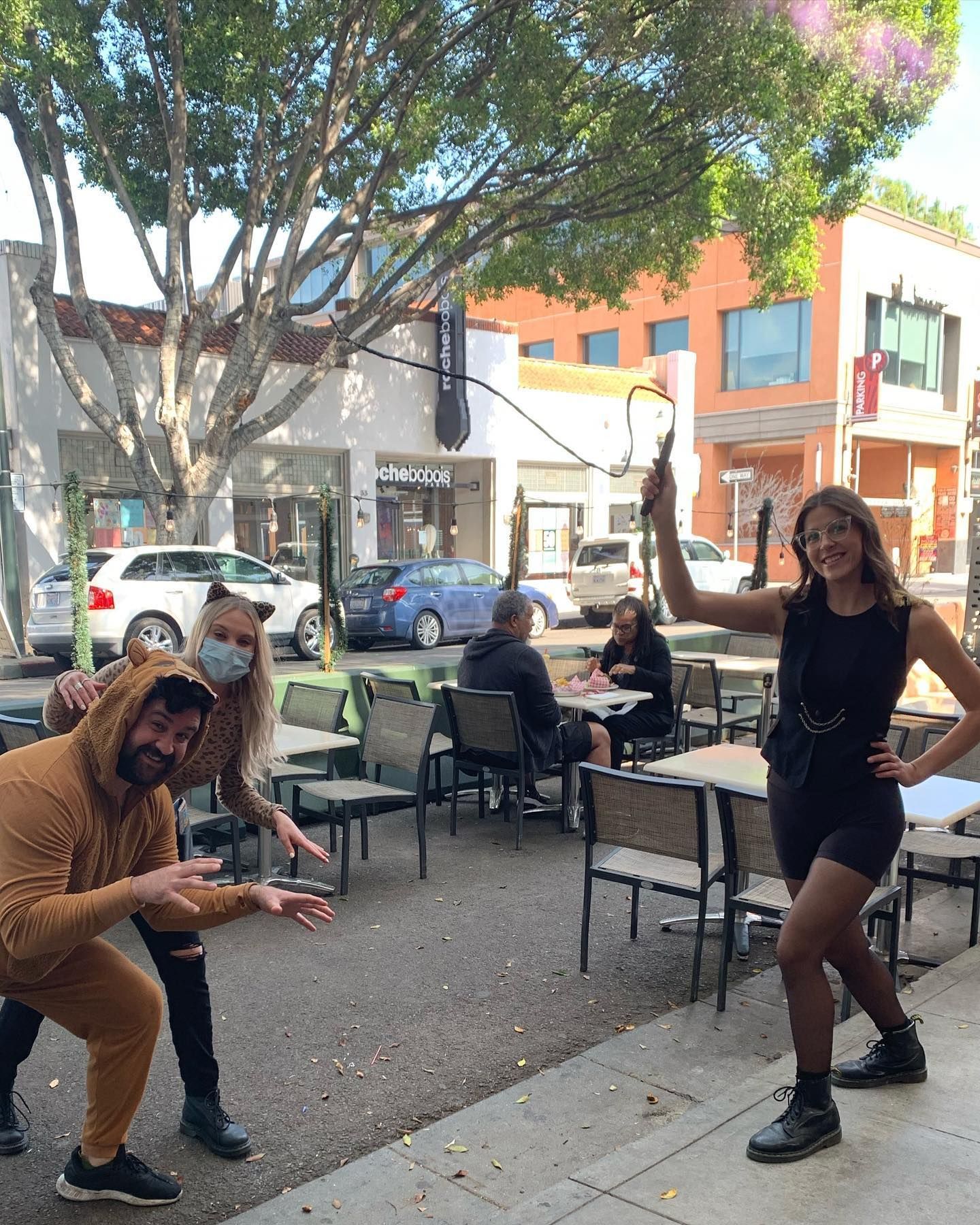 A man and a woman are posing for a picture in front of a restaurant.