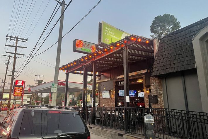 A car is parked in front of a restaurant.