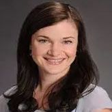 A woman with long dark hair is smiling for the camera.