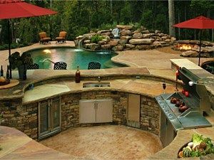 Backyard pool with curved stone bar, built-in grill, and red umbrellas around a landscaped patio