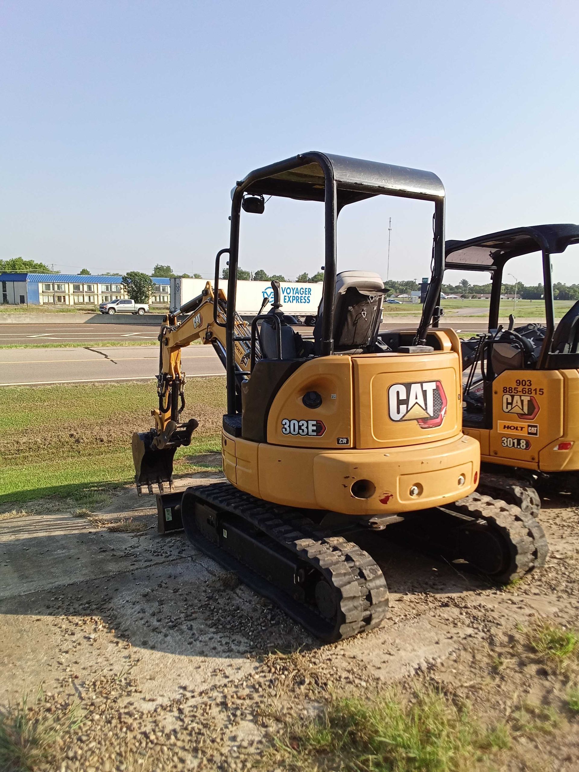 Yellow CAT mini excavator on tracks, outdoors.