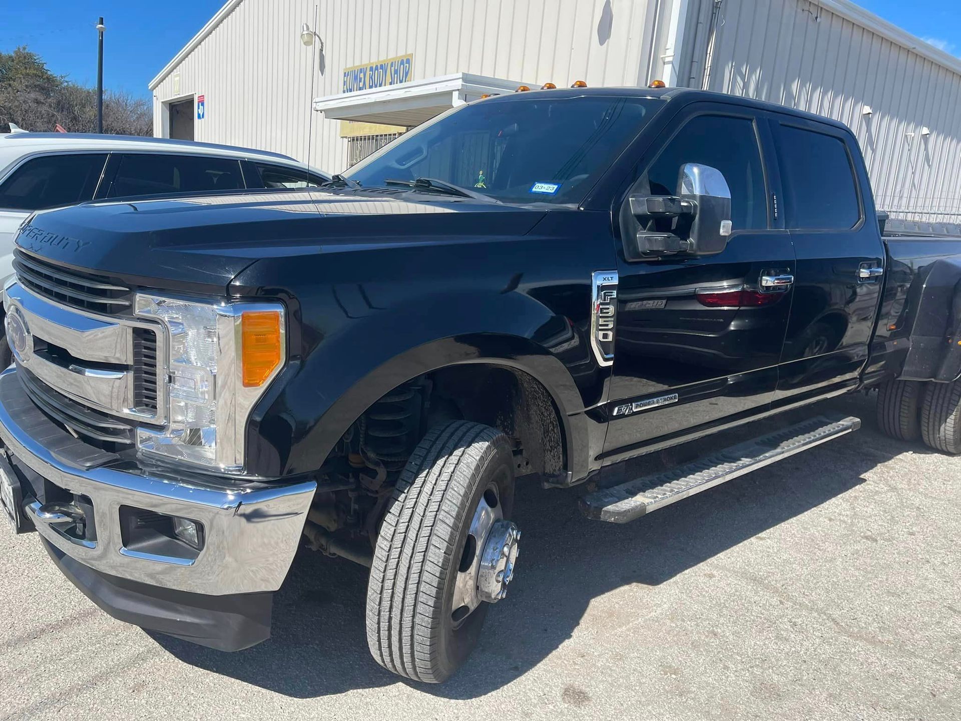 A black pickup truck is parked in front of a building.
